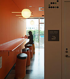 3階の喫煙室.カラフルな壁と照明や家具が,外部から見通せる.壁もホワイトボード化されている.